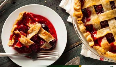 پای آلبالو خانگی با خمیر شبکه‌ای طلایی و یک برش در بشقاب